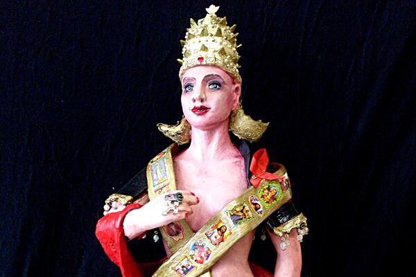 "Die Päpstin" – 80 x 25 cm, Ton, Zementspachtel, Heiligenbilder, Totenkopfring, Aidsschleife, Kondom - Almut Rybarsch-Tarry // Skulptur Objekt Wandgestaltung Installation